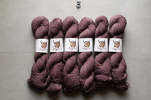 Load image into Gallery viewer, skeins of chunky yarn in a dusty mauve-purple color, arranged side by side on a neutral gray background. Each skein is wrapped with a white paper label featuring a brown bull illustration and the brand name 