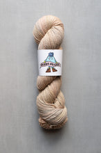 Load image into Gallery viewer, Beige skein of yarn with a label on a gray background