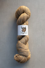 Load image into Gallery viewer, Beige skein of yarn with a label on a gray background