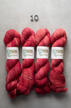 Load image into Gallery viewer, Four skeins of red yarn with labels on a gray background