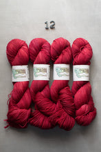 Load image into Gallery viewer, Four skeins of red yarn with labels on a gray background