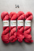 Load image into Gallery viewer, Four skeins of red yarn with labels on a gray background