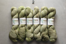Load image into Gallery viewer, Five skeins of green yarn with labels on a gray background