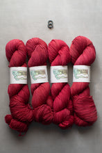 Load image into Gallery viewer, Four skeins of red yarn with labels on a gray background