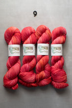 Load image into Gallery viewer, Four skeins of red yarn with labels on a gray background