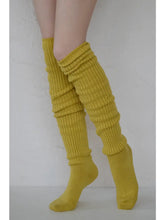 Load image into Gallery viewer, Yellow ribbed leg warmers worn over socks on a plain background