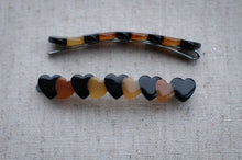 Load image into Gallery viewer, Hair clip with heart-shaped beads on a textured surface