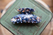 Load image into Gallery viewer, Marbled patterned hair clip on a green metal surface