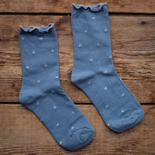 Load image into Gallery viewer, Pair of blue socks with heart patterns on a wooden surface
