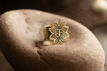 Load image into Gallery viewer, Gold floral earring on a stone surface
