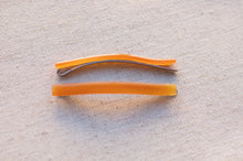 Load image into Gallery viewer, Two orange plastic tools on a textured beige surface