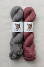 Load image into Gallery viewer, Two skeins of yarn on a light beige textured background. The left skein is heather gray with a white paper label showing a bison illustration and the brand name 'Best Lion Wolves'.