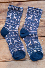 Load image into Gallery viewer, Pair of blue patterned socks on a wooden surface