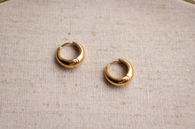 Load image into Gallery viewer, Gold hoop earrings on a textured beige fabric background