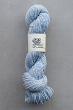 Load image into Gallery viewer, Light blue skein of yarn with a label on a gray background