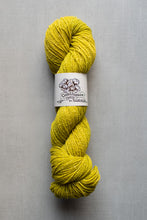 Load image into Gallery viewer, Yellow skein of yarn with a label on a gray background