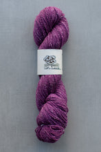 Load image into Gallery viewer, Purple skein of yarn with a label on a gray background