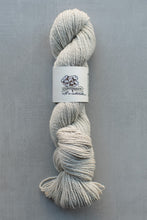 Load image into Gallery viewer, Gray skein of yarn with a label on a gray background