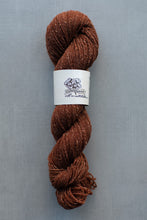 Load image into Gallery viewer, Brown skein of yarn with a label on a gray background