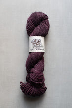 Load image into Gallery viewer, Ball of purple yarn with a label on a gray background
