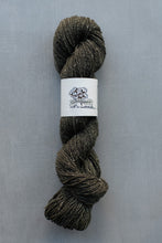 Load image into Gallery viewer, Skein of yarn with a label on a gray background