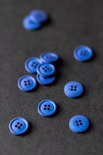 Load image into Gallery viewer, Blue buttons scattered on a dark surface