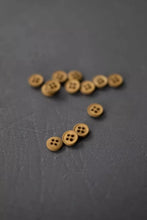 Load image into Gallery viewer, Brown buttons scattered on a dark gray surface