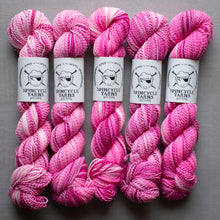 Load image into Gallery viewer, Pink yarn skeins with Spincycle Yarns labels on a gray background
