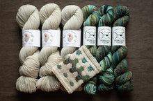 Load image into Gallery viewer, Spindles Yarns yarn skeins and a knitted item on a brown background