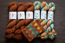 Load image into Gallery viewer, Three skeins of brown yarn and three skeins of multicolored yarn with a knitted swatch on a dark background.