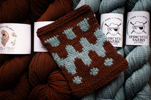 Knitted item with pattern surrounded by Spincycle Yarns yarn balls