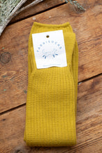 Load image into Gallery viewer, Mustard yellow sock with a label on a wooden surface
