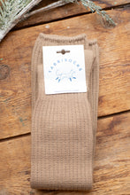Load image into Gallery viewer, Brown sock with a label on a wooden surface