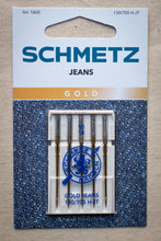 Load image into Gallery viewer, Pack of Schmetz jeans needles on a textured fabric background
