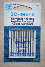 Load image into Gallery viewer, Pack of Schmetz universal needles on a textured fabric background
