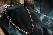 Load image into Gallery viewer, Gold chain necklace on a dark green fabric background