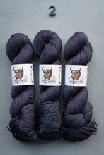 Load image into Gallery viewer, Three skeins of dark gray yarn with labels on a gray background