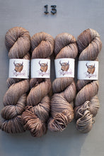 Load image into Gallery viewer, Four skeins of brown yarn with labels on a gray background