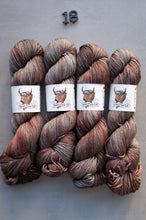 Load image into Gallery viewer, Four skeins of multicolored yarn with labels on a gray background
