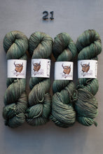 Load image into Gallery viewer, Four skeins of green yarn with labels on a gray background