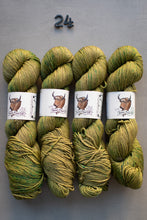 Load image into Gallery viewer, Four skeins of green yarn with labels on a gray background