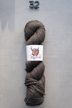 Load image into Gallery viewer, Gray skein of yarn with a label on a gray background