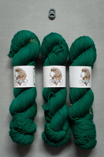 Load image into Gallery viewer, Three skeins of green yarn with labels on a gray background