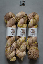 Load image into Gallery viewer, Three skeins of multicolored yarn with labels on a gray background