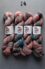 Load image into Gallery viewer, Four skeins of multicolored yarn with labels on a gray background