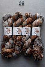 Load image into Gallery viewer, Four skeins of multicolored yarn with labels on a gray background