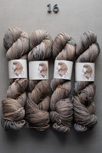 Load image into Gallery viewer, Four skeins of gray yarn with a brand label on a gray background