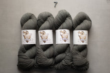 Load image into Gallery viewer, Four skeins of gray yarn with labels on a gray background