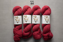 Load image into Gallery viewer, Four skeins of red yarn with labels on a gray background