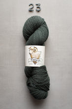Load image into Gallery viewer, Ball of dark gray yarn with a label on a light gray background